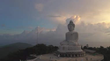Hava manzaralı gün batımı, yağmur bulutları yazın hareket ediyor. Güzel siluet Phuket, tepede büyük Buda. Turistlerin gelmesi için bir teşvik daha. Seyahat ve ibadet konsepti için 4k video