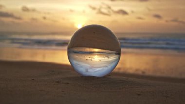 Gün batımında kristal kürenin içindeki güzel kumsal