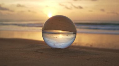 Sahilde altın gün batımında kristal küre