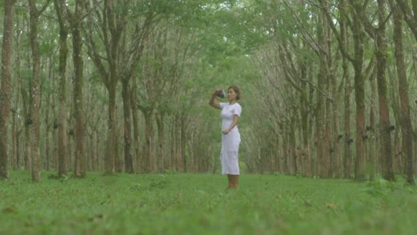 Uma Mulher Vestido Branco Usar Câmera Para Fotografar Campo Borracha — Vídeo de Stock