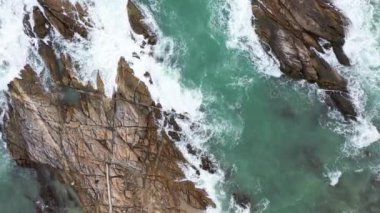 Sahilin yanındaki kayaya çarpan hava dalgaları. Kayadaki turkuaz denizde beyaz kabarcık dalgaları. yaratıcı doğa ve seyahat kavramı. 