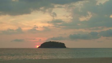 Manzara sarı güneş denize batıyor... güzel bulutlar tatlı gökyüzünde gün batımında Kata sahilinde Phuket Tayland 'da ve 4k stok video seyahat konseptinde..