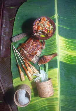 Yapışkan pirinç, papaya salatası, ızgara tavuk ve ızgara karides havuz başında servis edilir.