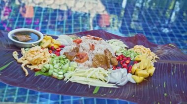 Arka planda kırmızı benekli muz yaprakları ile sunulan karides ezmeli kızarmış pirinç. Doğanın güzel rengi. yemek ve restoran konsepti.