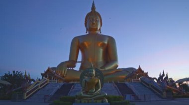 Muang Ang Thong Tayland 'da, Tayland' ın büyük altın Buda simgesi arkasında gün batımı. Dünyanın en büyük Buda heykeli pirinç tarlalarıyla çevrili. renkli gökyüzü arkaplanı