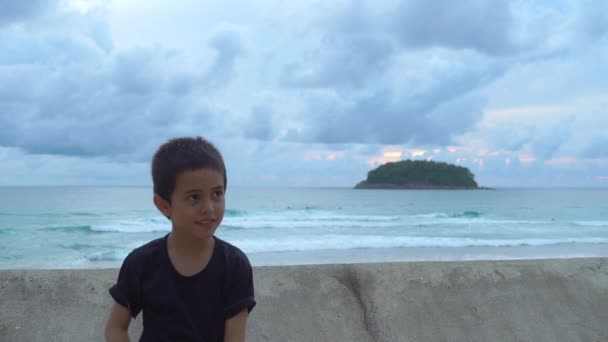 墙边一个厚脸皮的男孩拿着一个水晶球 背后有一个岛 — 图库视频影像