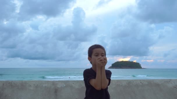 カタビーチプーケットタイの波の壁の横にクリスタルボールを持っている少年 日没の背景にある島の上の雲 リラックスコンセプト — ストック動画