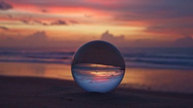 Alacakaranlıkta kristal küredeki güzel kumsal manzarası