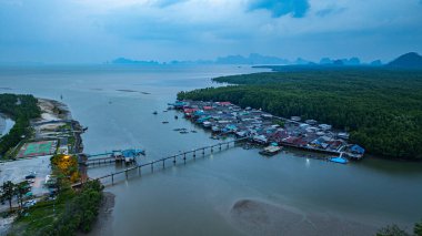 Küçük bir köprünün havadan görünüşü, mangrov ormanlarıyla çevrili küçük bir adada yaşayan bir balıkçı köyüne bağlanır. Önünde denize açılan bir kanal var, çeşitli deniz yaşamı açısından zengin..