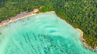 Morgan Köyü 'nün Surin Adası' ndaki doğal güzelliklere gizlenmiş havadan görüntüsü. Kıyı şeridi boyunca yemyeşil ormanlarla çevrili küçük kulübeler. Balıkçı tekneleri turkuaz sularda demirli..    