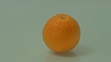 Olgun bir portakal, havadar bir parıltıyla çevrili rüya gibi yumuşak bir ışık sahnesinde yüzer. Kompozisyon saflığı, sağlığı ve doğal tazeliğin narin güzelliğini çağrıştırıyor..