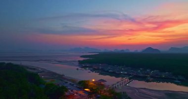 Alacakaranlıktaki Bang Phat balıkçı köyündeki gökyüzü manzarası. Mangrov ormanlarıyla çevrili küçük, ıssız bir adada yaşayan bir balıkçı köyündeki alacakaranlık gökyüzünün yansıması..