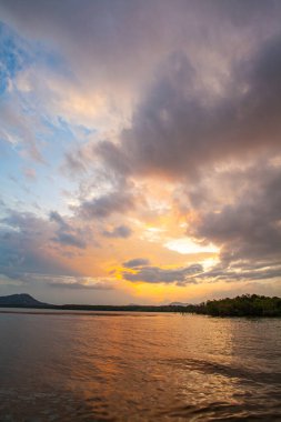 Altın güneş ışığı durgun sular boyunca uzanır. Uzak dağlara doğru hafifçe parlıyordu. Sakin atmosfer ve renkli yansımalar huzuru çağrıştırıyor. Gün batımında gölü mükemmel bir sığınak yapıyor.