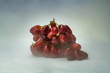 Ripe red grapes adorned with soft water droplets rest in serene light, expressing purity, freshness, and natures perfection an elegant symbol of vitality and natural sweetness