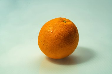 A fresh acid less orange surrounded by a thin mist, capturing the calm essence of morning freshness. The subtle moisture enhances its juicy texture and vibrant citrus tone.