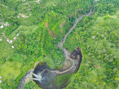 Havadan bakıldığında, Coban Sriti Şelalesi, vadiden aşağı akan ikiz şelale deresi. Su, göz alabildiğince sarmal dağ sırtlarına aktı. yeşil orman  