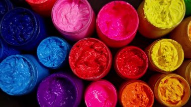 Renkli boya kapları birlikte dizilmiş.