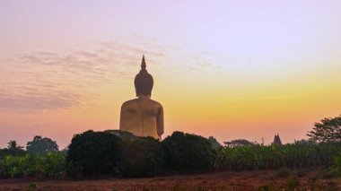Renkli günbatımına karşı Buda heykeli