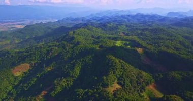 Mavi gökyüzünün altında yemyeşil dağlar