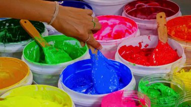 Konteynırlarda rengarenk boyalar karıştırıyorum.