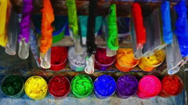 Renkli boya kapları düzgün düzenlenmiş.