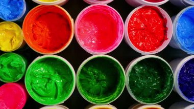 Renkli boya kapları düzgün düzenlenmiş.