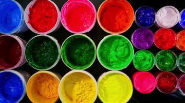 Renkli boya kapları düzgün düzenlenmiş.