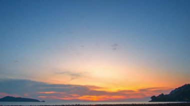 Denizde Akşam Bulutları. Sakin okyanusun üzerinde nefes kesici bir gün batımı. Ufuk boyunca harmanlanan altın ve pembe renkler. Dağılmış bulutlar, sakin bir akşam deniz manzarasında kaybolan ışığı yansıtıyor..
