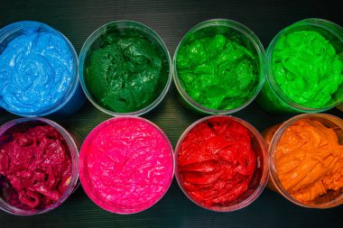 Boyalarla dolu renkli kaplar.