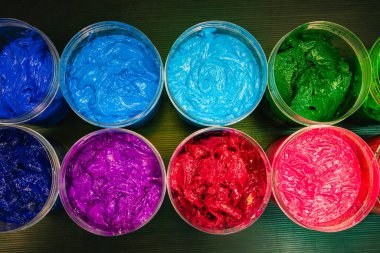 Boyalarla dolu renkli kaplar.