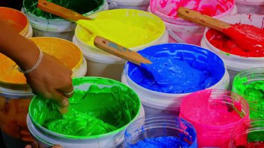 Beyaz kovada yeşil plastisol mürekkebi karıştıran