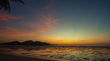 Adanın üzerindeki renkli gündoğumunda gökyüzünün zaman aşımı