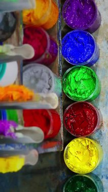 Sıra sıra dizilmiş renkli boya kapları