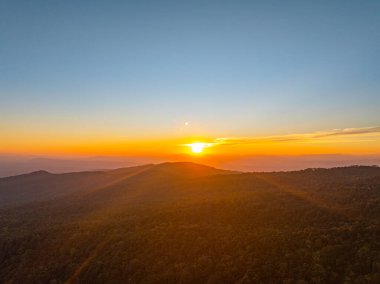 Değişen ışığın pürüzsüz akışında, güneş yükselen tepelerin ötesine yükselir, gökyüzünü parlayan bir tuvale dönüştürür. Zaman atlaması, engin dağ sıralarında şafağın dingin cazibesini ortaya çıkarıyor.