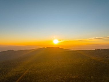 Değişen ışığın pürüzsüz akışında, güneş yükselen tepelerin ötesine yükselir, gökyüzünü parlayan bir tuvale dönüştürür. Zaman atlaması, engin dağ sıralarında şafağın dingin cazibesini ortaya çıkarıyor.
