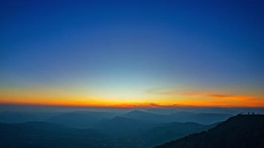 Katmanlı dağ sıralarının üzerinde nefes kesen bir gün batımı. Sıcak altın ışık, derin mavi gökyüzünde kayboluyor. Seyahat ve doğa temaları için ideal, dingin ve geniş bir doğal manzara yaratıyor..
