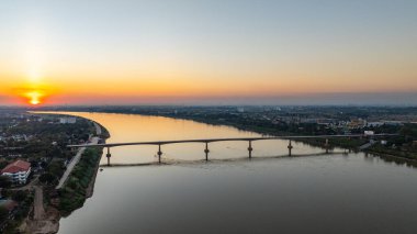 Kong nehri köprüsünde muhteşem bir gün batımı. Dramatik bulutlar, altın saat ışığı ve suya yansıyan yansımalar. Bu resim kentsel altyapı, ulaşım, şehir manzarası ve alacakaranlığı gösteriyor