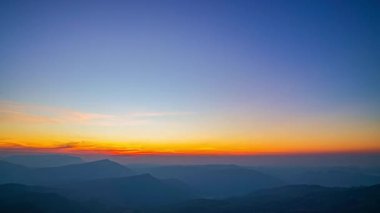 Güneşin doğuşunu gösteren sinematik bir hava aracı sisli bir dağ vadisine altın bir ışık tutuyor. Sis tabakaları orman tepeleri arasında sürüklenirken uzak tepeler renkli bir şafak vakti gökyüzünün altında parlarken sakin ve ilham verici bir doğa manzarası yaratıyor..
