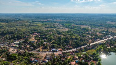 Nefes kesici bir dron perspektifi, yoğun ormanlarla çevrili engebeli bir dağ sırtı yakalar. Parlak beyaz bulutlar, parlak mavi gökyüzüne zıt düşer..