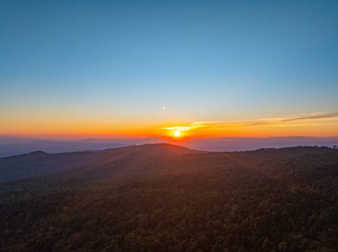 Değişen ışığın pürüzsüz akışında, güneş yükselen tepelerin ötesine yükselir, gökyüzünü parlayan bir tuvale dönüştürür. Zaman atlaması, engin dağ sıralarında şafağın dingin cazibesini ortaya çıkarıyor.