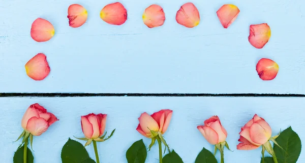 Mavi ahşap arka plan üzerinde parlak güller