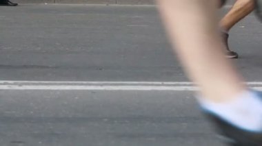 Kalabalık koşu ayakkabıları asfalt üzerinde soldan sağa doğru çalışıyor.