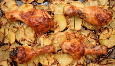 Patates ve soğanlı kızarmış tavuk budu ile yemek tepsisi.