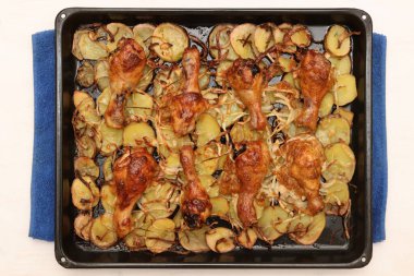 Patates ve soğanlı kızarmış tavuk budu tepsisi. Izgara öğle yemeği..