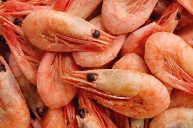 Kaynamış karidesler arka planda dosyalanıyor. Bir sürü karides dokusu.