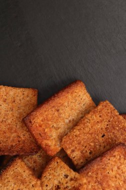 Siyah taş arka planda dağınık krakerler. Metin için yer.