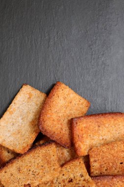 Siyah taş arka planda dağınık krakerler. Metin için yer.