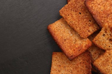 Siyah taş arka planda dağınık krakerler. Metin için yer.