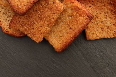 Siyah taş arka planda dağınık krakerler. Metin için yer.