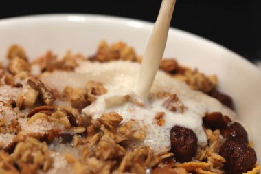 Çikolata toplu mısır gevreği dilimlenmiş muz ve süt deresi. Dolduruluyor. Makro yakın plan.